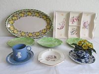 Overview of the seven ceramic and decorative items on a white surface with white wall background