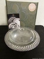 Photo showing Wilton Armetale packaging box with the Bubbles pattern casserole and glass lid in front, accompanied by an informational brochure.