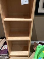 Front and side view of the IKEA Billy bookcase showing three shelves and light wood finish.