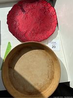 Photo showing the red Christmas platter with embossed snowflake design and the beige round cooking stone dish below it.