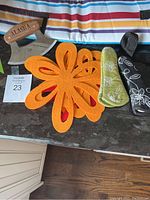 Full view of felt pan protectors, pan handle protectors in green and black fabric, Alaska chopping tool, and wine cooler bag on counter