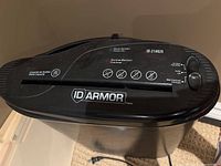 Close-up of ID Armor paper shredder top panel showing model number and control dial