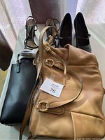 Top view of two purses and two pairs of shoes arranged on surface, showing overall condition and details of hardware and styles.