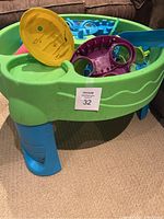 Water play table assembled, showing green basin with blue legs and attached play features.