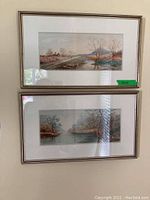 Two framed landscape prints stacked vertically on a wall