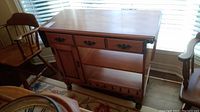 Full front and side view of the wooden Roxton server showing drawers, door, open shelf, base rack, and drop leaves folded down.