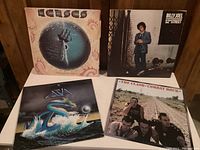 Four vinyl record albums: Kansas 'Point of Know Return', Billy Joel '52nd Street', Asia self-titled, The Clash 'Combat Rock'. Shown together from front.