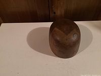 Top and side view of antique wooden hat mold showing rounded shape and two-tone wood finish.