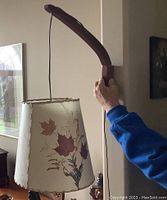 Full view of lamp with shade showing leaf and botanical printed pattern and stitched edge trim.