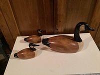 Front view of three decoys: one large and two smaller on display