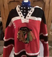 Front view of the black, red, and white Chicago Blackhawks hoodie with embroidered team logo and number 19 on the sleeve.