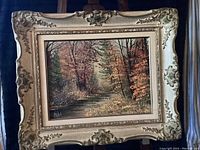 Frontal view of the framed oil painting showing full artwork and ornate frame.