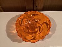 Top view of the mid century modern orange art glass bowl showing swirling patterns.