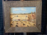 Framed oil painting showing the marshland scene and artist signature.