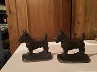 Front view of both cast metal Scotty dog bookends showing overall shape and size.