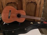 Side view of Yamaha G-50A acoustic guitar on top of its case, showing full body and neck, natural wood finish.