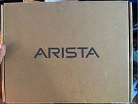 Closed cardboard box with Arista branding on top.