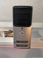 Front view of Dell Dimension E521 desktop tower showing drive bays, USB ports, audio jacks, and ventilation.