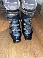 Front view pair of Salomon Evolution ski boots on wooden floor showing the overall condition and design.