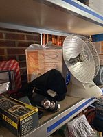 White oscillating heater fan on shelf with trailer hitch and filters