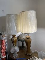 Overview of all four table lamps including two amber ceramic lamps with shades, the pressed glass lamp, and the Tiffany-style lamp