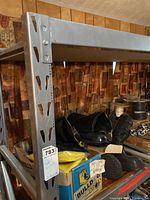 Heavy duty metal shelf with adjustable shelves, loaded with black waterproof boots and Bulldog brand boot boxes.