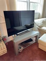 Wide shot showing Sony TV on stand with Blu-ray player in lower shelf