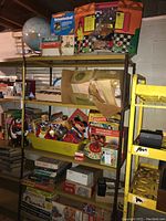 Shelf with multiple vintage boxed toys and games including Splashketball and a giraffe puzzle box.