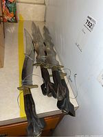 Photo of four traditional Filipino kris daggers showing wavy blades and carved wooden handles on a countertop.