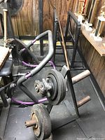 Weight stand showing loaded weight bars and ab roller on the floor next to it