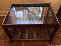 Top view showing clear glass top with dark wood frame and reflections of surrounding windows.