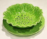 Two-piece green leaf compote set stacked, showing plate and bowl with perforations