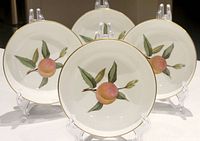 Front view of four Royal Worcester Evesham dessert dishes with peach and leaf design, gold trim, displayed on clear stands.