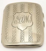 Full view of the rectangular silver plated smoker's case exhibiting engraved monogram and patterned surface