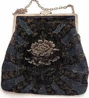 Front view of the vintage handbag showing the floral fabric print and metal frame with chain handle.