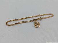 Entire bracelet laid flat on white background showing chain and fish charms