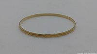 Side-on view of bangle showing etched pattern along outer surface