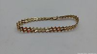 Curved view of the gold link bracelet on white background