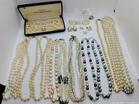 Overview of all items laid out: eight necklaces, one bracelet, four pairs of earrings