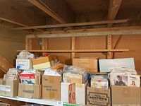 Wide view of boxes on a shelf containing assorted vintage sewing patterns from multiple brands including Butterick and Vogue, with various sizes and conditions from new to used.