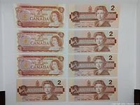 Full view of all 8 Canadian 2 dollar bills; 3 from 1974 on left and 5 from 1986 on right.