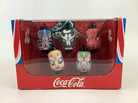 Front view of the Coca-Cola collectibles box showing five Beijing Olympics themed ornaments inside with clear visibility of designs and Coca-Cola branding.