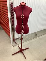 Full view of red adjustable dress form on metal base