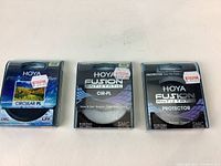 Three Hoya camera lens filters in boxes: left 58 mm Circular PL new, middle 46 mm Fusion Antistatic CIR-PL new, right 52 mm Fusion Antistatic Protector used