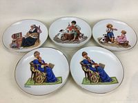 Top view of the 5 Norman Rockwell collector plates arranged on a white surface showing the artwork on each plate.