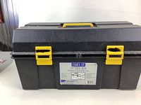 Front view of rectangular black plastic tool box with yellow handle and latches, showing the product label on front.