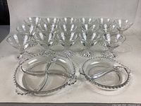 Front view of 12 etched floral pattern vintage glasses and two divided beaded edge plates, cornflower relish tray and divided plate shown.