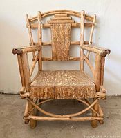 Front view of vintage large Buckhorn Reserve stick chair showing solid wood plank seat and decorative backrest with natural wood structure.