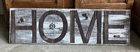 Full photo of the large HOME sign on the floor showing entire piece.