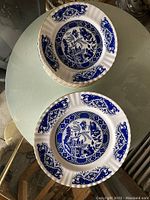 Stack of eight 10.5 inch Royal Staffordshire plates, blue and white pattern, scalloped gold rims.
